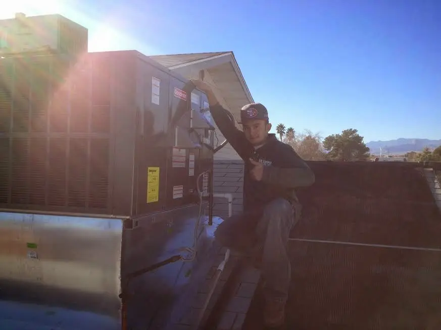 HVAC technician performing AC Tune-Up on a rooftop unit in Tinley Park