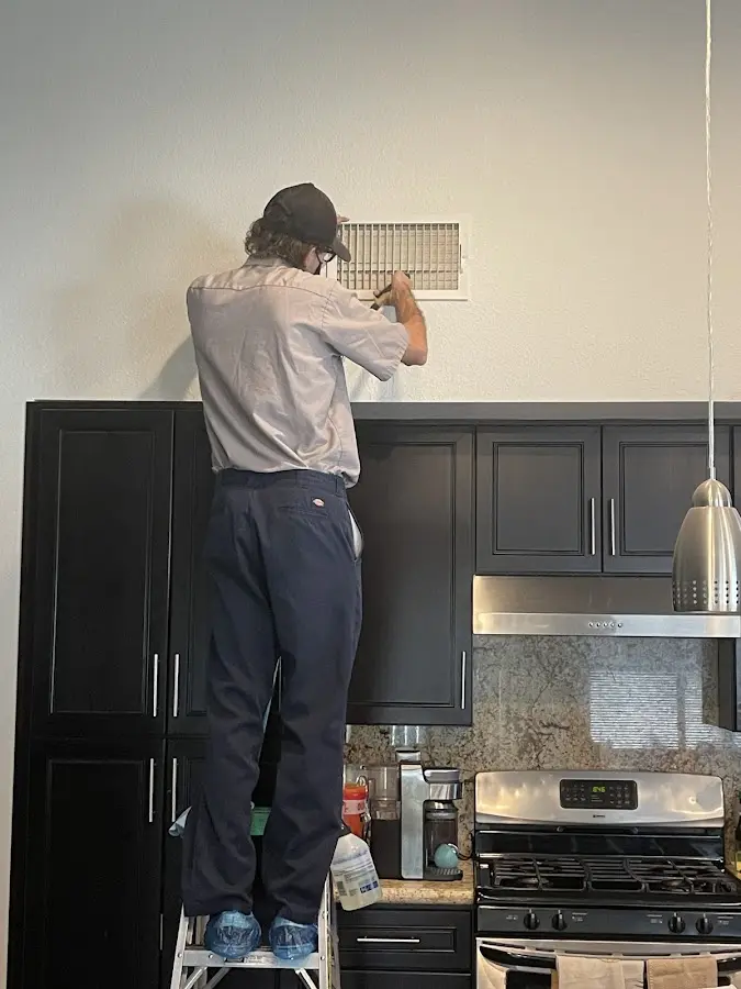 Technician inspecting an air vent during HVAC service in Tinley Park
